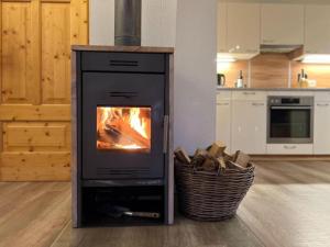 - une cuisinière dans la cuisine avec une cheminée dans l'établissement Sauna Chalet Ahorn, à Staudach