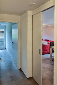 an open door to a living room with a red couch at Weiherhof in Wildhaus