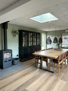 jadalnia z drewnianym stołem i kuchenką w obiekcie Summer House Near The Beach At Grønninghoved w mieście Binderup Strand