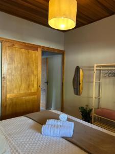 Un dormitorio con una cama con dos toallas encima. en Recanto no Centro, en São Francisco Xavier