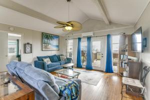 a living room with blue couches and a ceiling fan at Ocean Views Second-Row Surfside Beach House in Surfside Beach
