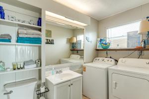 a bathroom with a sink and a washer and dryer at Ocean Views Second-Row Surfside Beach House in Surfside Beach +26 photos