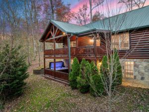 uma cabana na floresta com um grande deque em Holliebear's Hideaway em Waldens Creek