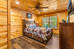 um quarto num chalé de madeira com uma cama e uma ventoinha de tecto em Holliebear's Hideaway em Waldens Creek