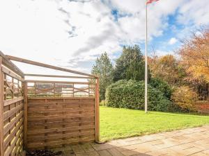 Emmerlev4 star holiday home in Højer的院子里的木栅栏上插着一面旗子