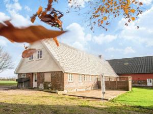Emmerlev4 star holiday home in Højer的一座大型砖砌建筑,前面有一座庭院