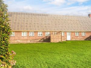 Emmerlev4 star holiday home in Højer的一座大型红砖建筑,有大院子