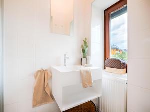 a white bathroom with a sink and a window at Family-Friendly Apartment in Graz in Graz Ostbahnhof +24 photos