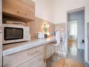 a kitchen with a counter with a microwave and a stool at Family-Friendly Apartment in Graz in Graz Ostbahnhof