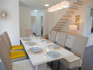 a dining room with a white table and white chairs at Holiday home with partial sea view, Douarnenez in Tréboul