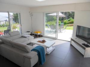 a living room with a couch and a flat screen tv at Holiday home with partial sea view, Douarnenez in Tréboul