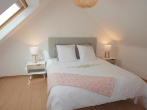 a bedroom with a large white bed with a pink blanket at Holiday home with partial sea view, Douarnenez in Tréboul