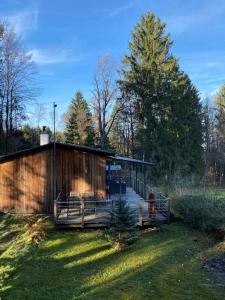 un bâtiment en bois avec une terrasse dans l'herbe dans l'établissement Herzhütte Für Zwei, à Vichtenstein