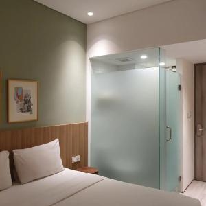 ein Schlafzimmer mit einem Bett und einer Glasduschtür in der Unterkunft Lenarda hotel in Nggorang