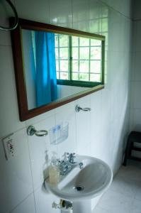 Un baño con lavabo, espejo y ventana. en Finca campestre San Juan, un paraíso en medio de la naturaleza, en San Gil