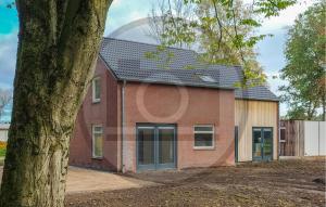 a red brick house with a large window at Stunning Home In Afferden in Afferden