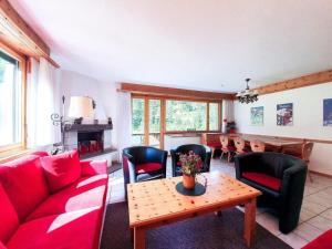 uma sala de estar com um sofá vermelho, cadeiras e uma mesa em Curtins16 em Pontresina