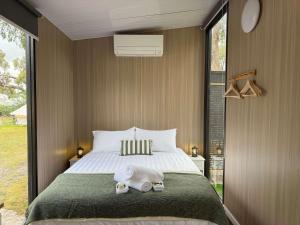 um quarto com uma cama com dois bichinhos de pelúcia em Bush Hideaway X at Tiny Away em Glenroy