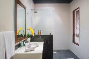 a white bathroom with a sink and a mirror at Tranquil 2BR Villa, Near Canguu and Pererenan in Tumbak Bayuh +25 photos