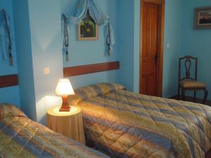 Un dormitorio con dos camas y una lámpara sobre una mesa. en Fuerte de San Mauricio, en Palazuelo de Vedija