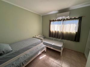 ein Schlafzimmer mit zwei Einzelbetten und einem Fenster in der Unterkunft EL DEPTO DE GRACE in San Pedro