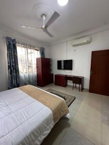 Un dormitorio con una cama y un ventilador de techo. en Phaneros Apartment, en Accra