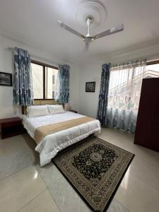 1 dormitorio con 1 cama grande con cortinas azules y alfombra en Phaneros Apartment, en Accra 25 fotos más