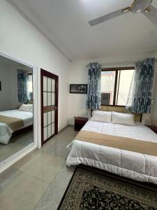 Un dormitorio con dos camas y una gran ventana. en Phaneros Apartment, en Accra