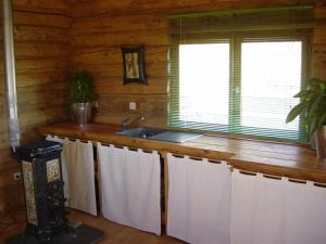 a kitchen with a sink and a counter with towels at Log Cabin in the Loire Valley in Ambillou-Château