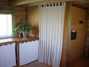 a room with a white curtain and a window at Log Cabin in the Loire Valley in Ambillou-Château