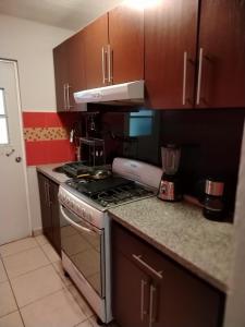 une cuisine avec des armoires en bois et un four à plaques de cuisson dans l'établissement Bonaterra, à El Jobo