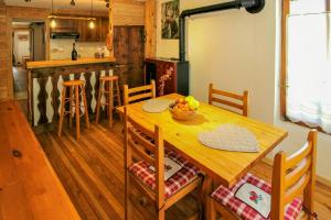 eine Küche mit einem Holztisch mit einer Obstschale darauf in der Unterkunft Stone Cabin With Views Over Balme Valley in Alo di Stura