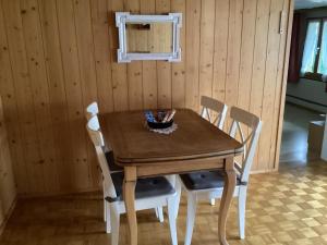 una mesa de madera con 4 sillas y un tazón. en Mannried 2 1 2 Zimmerwohnung Rustikal, en Zweisimmen
