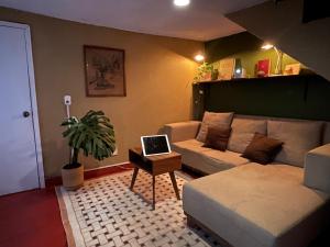 ein Wohnzimmer mit einer Couch und einem Laptop auf einem Tisch in der Unterkunft Botanique Concept House Guanajuato Centro in Guanajuato
