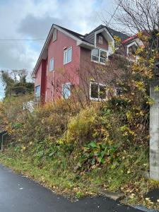 een roze huis op een heuvel bij 青山ハウス in Otaru +28 foto's