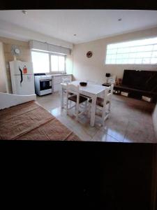 a kitchen with a white table and a white refrigerator at Lajas del Parque in Tandil
