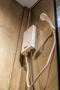 eine Dusche mit einem weißen Schlauch an der Wand in der Unterkunft CIELO Siargao in General Luna