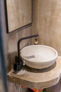 ein Steinwaschbecken auf einer Holzablage in einem Badezimmer in der Unterkunft CIELO Siargao in General Luna + 27 Fotos