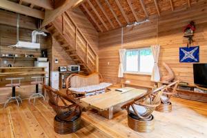 a dining room with a table and chairs in a log cabin at 源泉ログの宿 in Sobetsu +46 photos