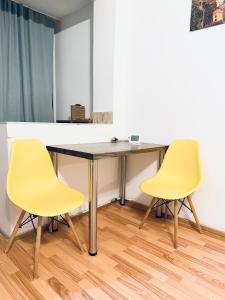 dos sillas amarillas sentadas a una mesa en una habitación en Take Ionescu Center Studio Apartment, en Timisoara 2 fotos más