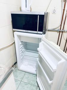 Un microondas encima de un refrigerador abierto. en Take Ionescu Center Studio Apartment, en Timisoara