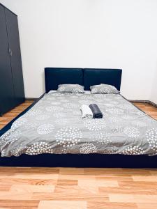 Una cama con un edredón gris y blanco. en Take Ionescu Center Studio Apartment, en Timisoara