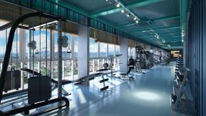 ein Fitnessstudio mit Laufbändern und Crosstrainern und Fenstern in der Unterkunft Ipoh Anderson Condo - 2BR in Ipoh