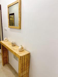 a bathroom with a mirror and a wooden counter at Paradis Douillet in Cotonou +3 photos