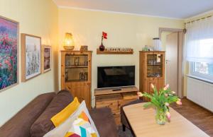 ein Wohnzimmer mit Sofa und Fernseher in der Unterkunft Ferienhaus in Alt-Schadow mit Grill und Terrasse - b58184 in Markische Heide