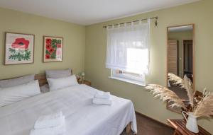 ein Schlafzimmer mit einem weißen Bett und einem Fenster in der Unterkunft Ferienhaus in Alt-Schadow mit Grill und Terrasse - b58184 in Markische Heide