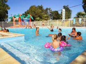 a group of children playing in a swimming pool at Mobil-home cosy avec terrasse pour 2 personnes - API-1-52-276 in Saint-Sornin