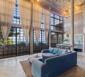 a living room with a blue couch and large windows at Summer Salt Beach Casita in Punta Mita