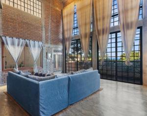 a living room with a blue couch in a room with windows at Summer Salt Beach Casita in Punta Mita
