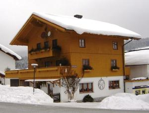 ein großes Holzgebäude mit Schnee darüber in der Unterkunft Ferienwohnung Koch in Bayerisch Eisenstein